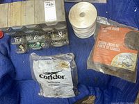Photo showing plastic organizer with drawers plus stack of white washers, protective gloves in packaging, and garage door seal in packaging.