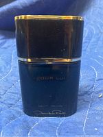 Photo shows a dark blue 90 mL bottle of Oscar De La Renta For Him Eau de Toilette with gold trim and black cap