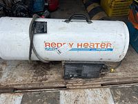 Side view of white cylindrical propane heater with control panel and handle; labeled 'Reddy Heater Pro'.