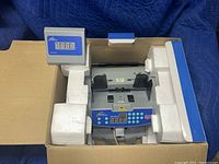 Royal Sovereign RS RBC-1003 cash counter inside packaging showing device with digital display and control panel.
