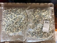 Two sealed plastic bags filled with hex head screws with plastic washer caps, shown for inventory and quantity.