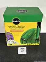 Front of box displaying brand Miracle-Gro, hose length 100 ft, diameter 5/8 inch, pressure rating 600 PSI, and product image.