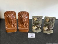 Photo of two pairs of bookends: one Native American head carved set and one cowboy figure set