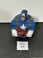Front view of blue, white, and brown Captain America bust coin bank with arms crossed.