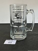 Clear glass mug with handle showing front view with Rocky Mountain graphic and text 'SHOOTER' beneath.