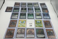 Photo displaying 28 TCG cards in protective sleeves from Pokemon, YuGiOh, World of Warcraft, and Magic the Gathering.