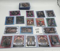 Photo showing UFC cards including autographed rookie cards encased in plastic holders, numbered parallels, inserts, and other fighter cards arranged neatly on a white surface.