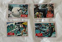 Four Batman cards laid out front side up, showing colorful comic scenes with red bordered captions.