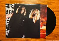 Vinyl record with cover showing two band members against dark background.