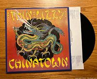 Front cover of Thin Lizzy's "Chinatown" album featuring colorful dragon artwork with orange background.