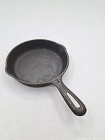 Angled view highlighting the skillet's interior surface and spouts, showing the seasoned cast iron material.