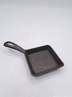 Full view of the vintage cast iron square pan showing shape, handle, and condition.