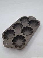 Additional photo of the cast iron Turks pan showing the same seven cavities and pan shape for clear viewing.