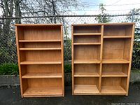 Another front view image of the two oak bookcases outdoors with clear natural lighting