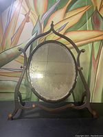 Repeat front view of vanity mirror highlighting its design and age-related wear