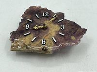 Top angle showing the full face of the polished amethyst clock with visible clock hands and hour markers.