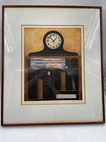 Full view of one framed print showing a wooden mantle clock illustration with compartments below and clock face showing 10:12