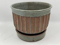 Front view of a vintage pottery planter showing vertical ribbed design with a speckled gray glaze on rim and base.