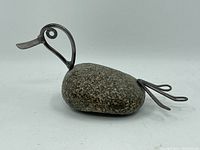 Side view of welded duck sculpture showing river rock body and metal head and tail