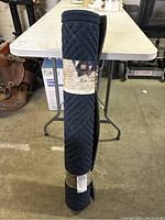 View of one rolled commercial entry mat showing the textured pattern and size wrap label (3'x5').