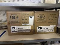 Two sealed cardboard boxes each labeled to contain 20 silver Mophie Juice Pack Helium battery cases for iPhone 5/5S, stacked on shelf.