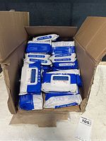 Box filled with many sealed packs of alcohol wipes in blue and white packaging.