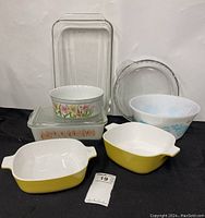 Full lot displaying various glass and ceramic baking dishes with floral and patterned decorations.