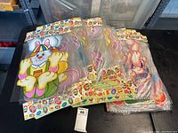 Six large Easter bunny decorative cutouts packaged in clear plastic with colorful printed cardboard headers, showing cartoon bunnies in pastel colors.
