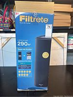 Front and side view of the 3M Filtrete Tower Air Purifier box highlighting large room capacity of 290 sq ft and replacement filter options.