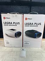Front of the boxes showing Lifepro Legra Plus Hand Massager branding and product images for the white and black models.
