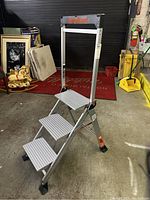 Full view of the Little Giant aluminum folding stepstool with three wide steps and handle bar.