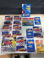Complete lot of eleven die-cast cars new in packaging, showing front view of packages featuring variety of Hot Wheels Superstars, Micro Machines, and Matchbox cars.