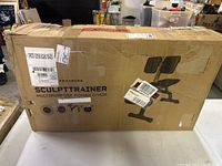 Front side of the Sculpttrainer box with image of the Roman workout chair and branding labels.