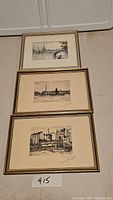 Three framed Paris prints stacked vertically, showing detailed black and white etchings with gold frames.