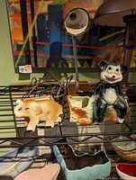 Photo showing two ceramic animal planters: an orange and white elephant and a black and white bear with a small planter attached.