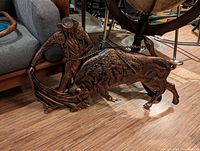 Photo of a plastic bullfighter and bull figurine on a wooden floor showing detailed traditional attire and dynamic pose