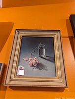 Framed Tretchikoff print shows the artwork of a single pink rose and glass of water laid on a smooth surface, with signature visible and a beige wooden frame.