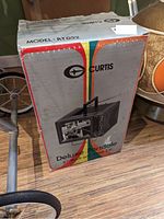 Original box of the Curtis Deluxe Portable 5 inch black and white TV model RT032 with colorful stripes and logo visible