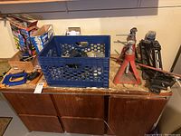 Overall view of the tools and storage crate arranged on a wooden surface.