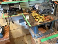 Overview of lot items including bench grinder, motor, and trouble light on workbench