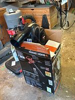 Photo showing Craftsman handheld blower placed inside the Black & Decker branded box, depicting overall lot contents and packaging.