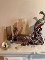 Photo of the lot showing large bird figurines, marble horse head, anniversary plaque, mini bears, and wedding snow globe on a shelf.
