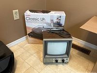 Ion Classic LP USB turntable in original box alongside a vintage Telefunken small TV set with wood grain sides.