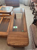 Sofa table showing wood surface with glass insert and lower shelf.