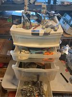 Overall view of multiple Star Wars vehicles and figures displayed in storage drawers showing toys in used condition.