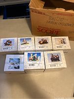 Seven Fitz and Floyd Charming Tails collectible figurines in their original boxes displayed on table, showing box artwork and condition.