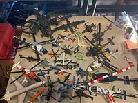 Overall view of diecast aircraft collection showing a wide assortment of helicopters, jets, and airliners on table, emphasizing diversity and quantity.