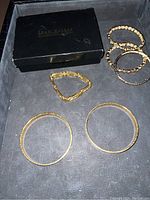 Lot of six gold tone bracelets in black Joan Rivers Classic Collection box.