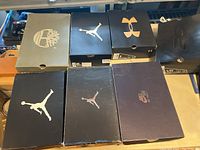 Twelve shoe boxes stacked including Timberland, Air Jordan, Under Armour, and Nike boxes