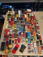 Top view of entire lot showing rows of various vintage Hot Wheels cars and trucks arranged closely together on a table